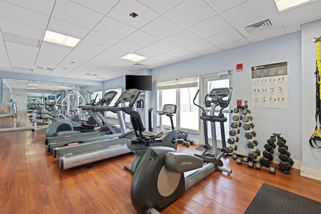 exercise room with hardwood / wood-style flooring and a drop ceiling