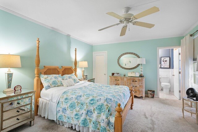 bedroom with ceiling fan, ensuite bathroom, light carpet, a closet, and ornamental molding