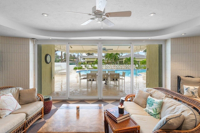 living room with ceiling fan, a healthy amount of sunlight, and a textured ceiling