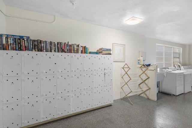 miscellaneous room featuring washer and clothes dryer and a textured ceiling