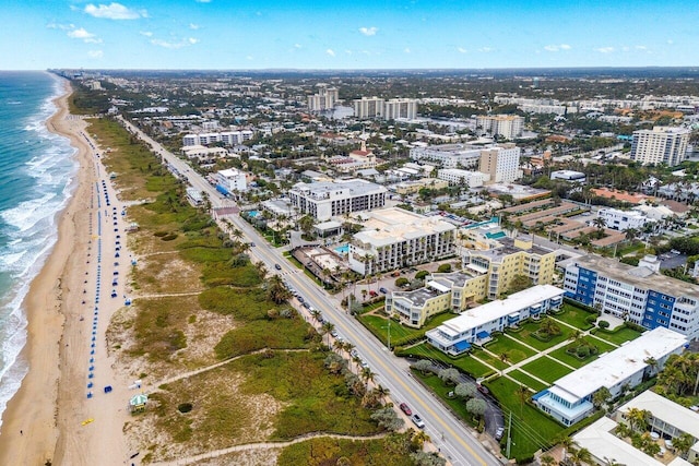 drone / aerial view featuring a water view and a view of the beach