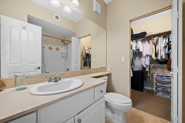 bathroom featuring vanity, toilet, a shower, and tile patterned floors