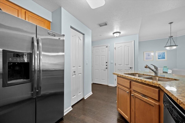 kitchen with pendant lighting, dishwasher, sink, stainless steel fridge, and light stone counters