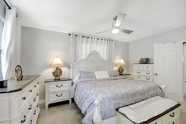 bedroom featuring ceiling fan, light tile patterned floors, and multiple windows