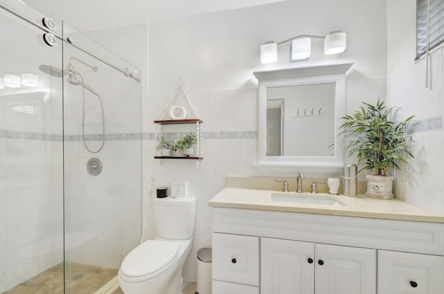 bathroom with toilet, vanity, tile walls, and a shower with shower door