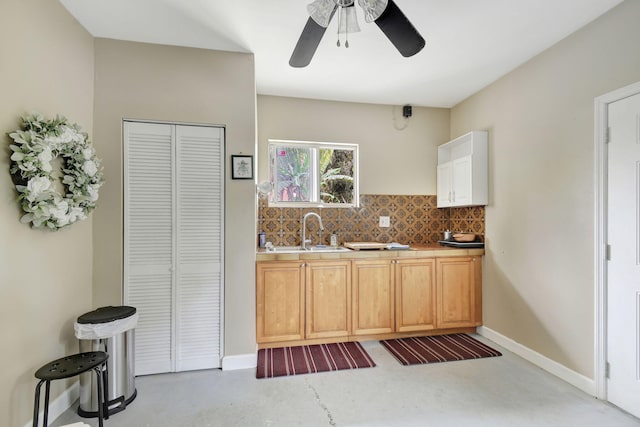 kitchen featuring ceiling fan, tasteful backsplash, and sink