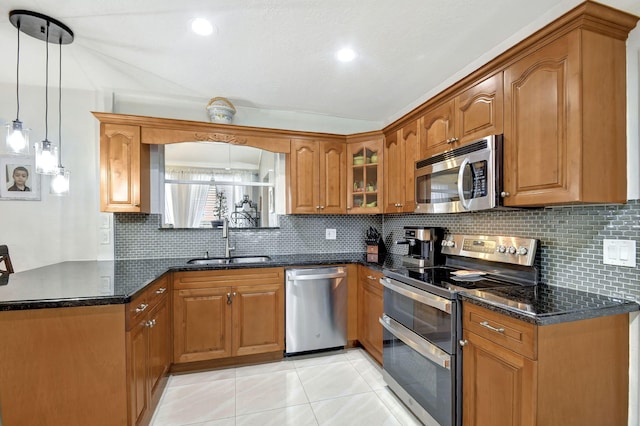 kitchen with light tile patterned floors, stainless steel appliances, tasteful backsplash, decorative light fixtures, and sink