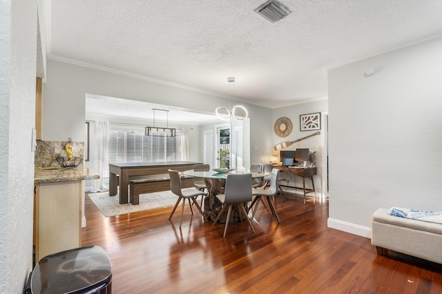 dining area featuring wood-type flooring, a textured ceiling, and ornamental molding