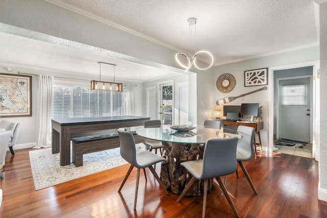 dining space with crown molding, wood-type flooring, and a textured ceiling