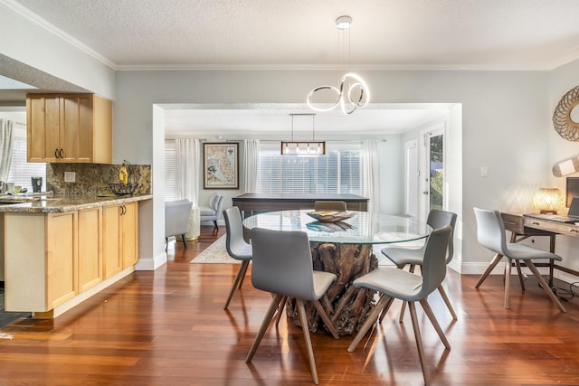 dining room featuring a textured ceiling, crown molding, dark wood-type flooring, and a notable chandelier