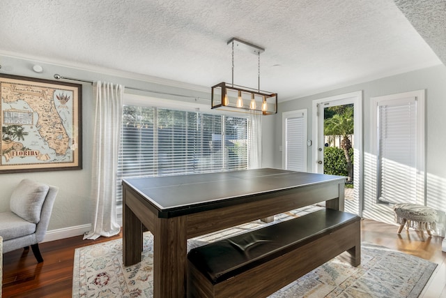 dining area featuring a textured ceiling, dark hardwood / wood-style floors, and ornamental molding