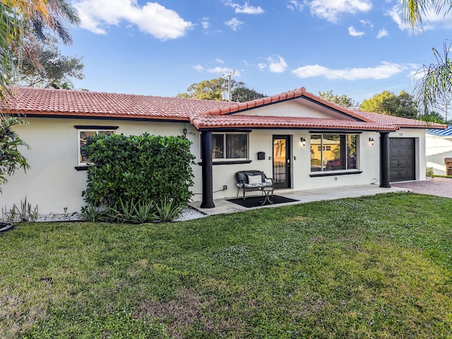 rear view of property featuring a yard and a garage