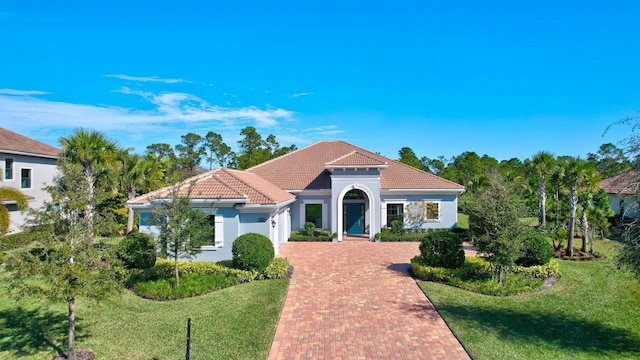 mediterranean / spanish home with a front lawn