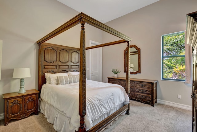 bedroom with vaulted ceiling and light colored carpet