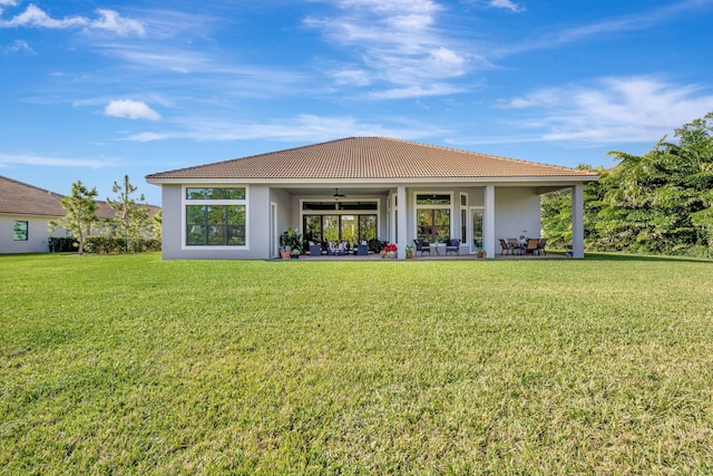 rear view of house with a lawn, ceiling fan, and a patio area