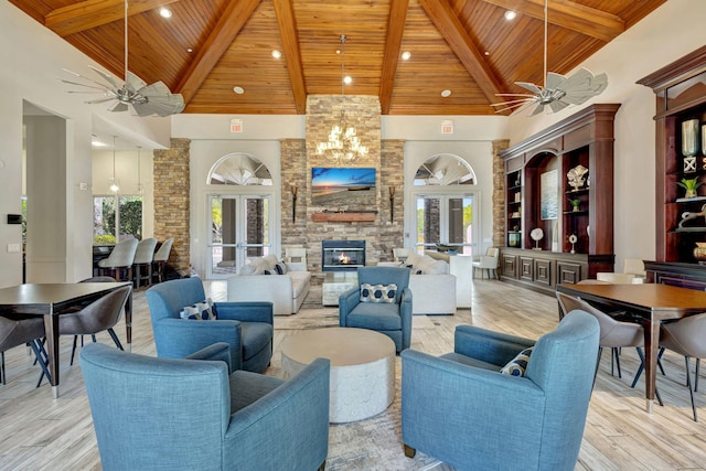 living room featuring wood ceiling, ceiling fan with notable chandelier, and high vaulted ceiling