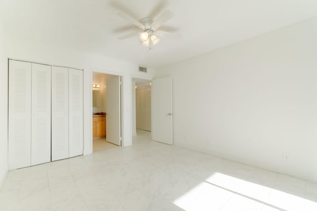 unfurnished bedroom featuring ensuite bath, a closet, and ceiling fan