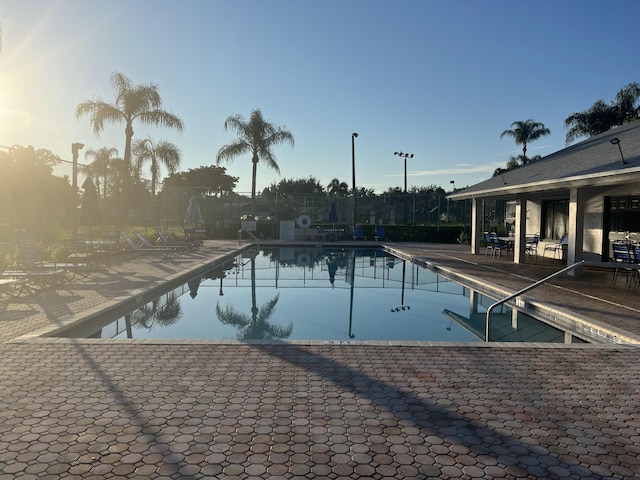 pool at dusk featuring a patio