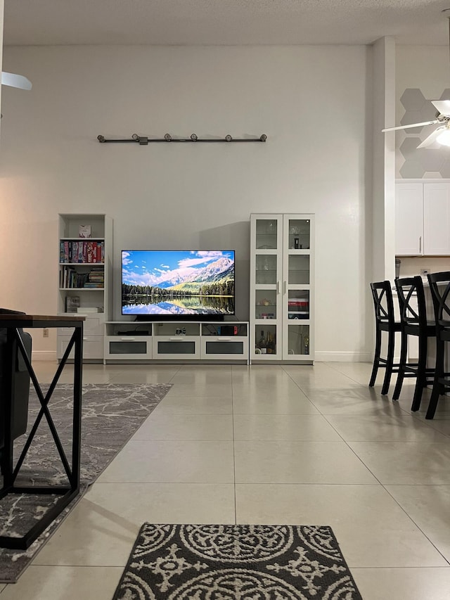 living room featuring ceiling fan and light tile patterned floors