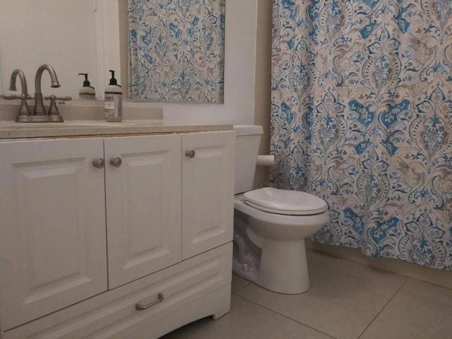 bathroom featuring toilet, vanity, tile patterned floors, and a shower with curtain