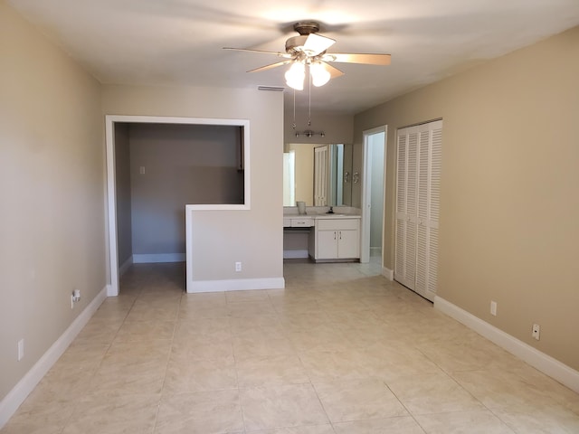 unfurnished bedroom with ceiling fan, sink, connected bathroom, and light tile patterned flooring