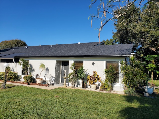 back of property featuring a lawn and a patio