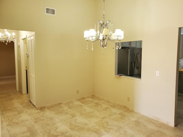 unfurnished dining area featuring a chandelier