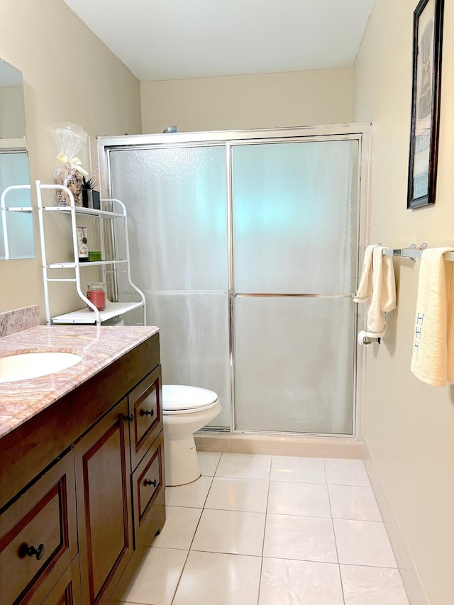 bathroom featuring a shower with shower door, tile patterned floors, vanity, and toilet