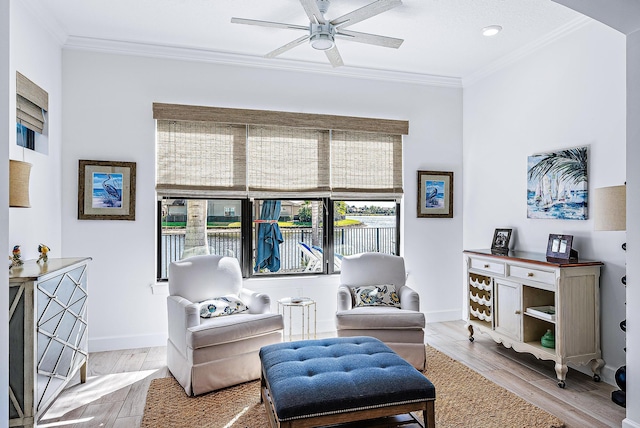 sitting room featuring ornamental molding, ceiling fan, and light hardwood / wood-style flooring