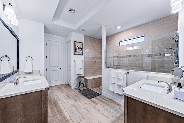 bathroom featuring tiled shower and vanity