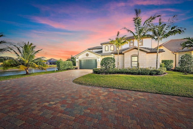 mediterranean / spanish home with a yard, a water view, and a garage