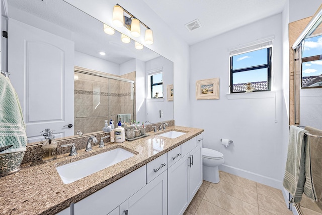 bathroom featuring walk in shower, vanity, tile patterned floors, and toilet