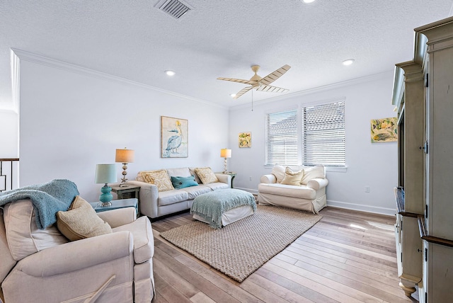 living room featuring a textured ceiling, ceiling fan, and crown molding