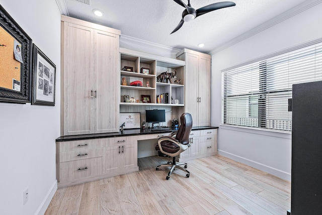 office with built in desk, a textured ceiling, ceiling fan, light hardwood / wood-style flooring, and crown molding