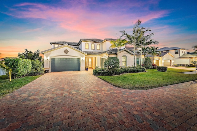 mediterranean / spanish house featuring a lawn and a garage