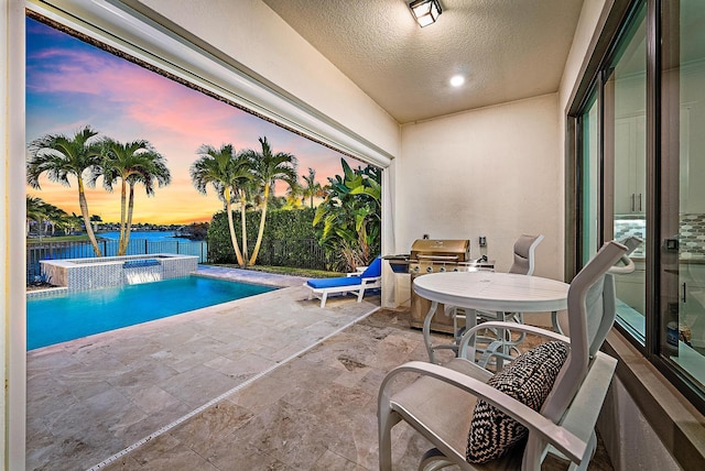 pool at dusk with grilling area and a water view