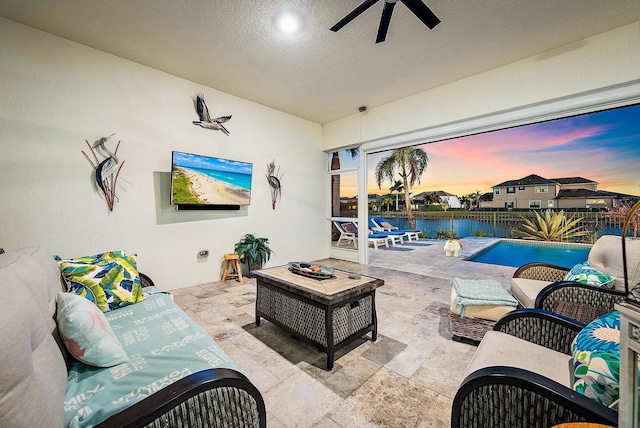 view of patio featuring an outdoor living space with a fire pit, ceiling fan, and a fenced in pool