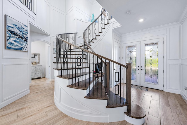 foyer entrance featuring french doors and crown molding