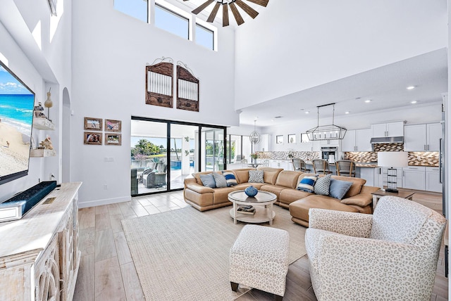 living room featuring a towering ceiling and ceiling fan