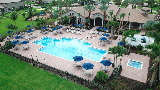 view of swimming pool featuring a hot tub, a patio, and a yard