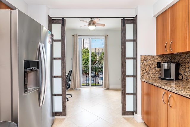 kitchen featuring light stone countertops, stainless steel fridge, backsplash, ceiling fan, and light tile patterned floors