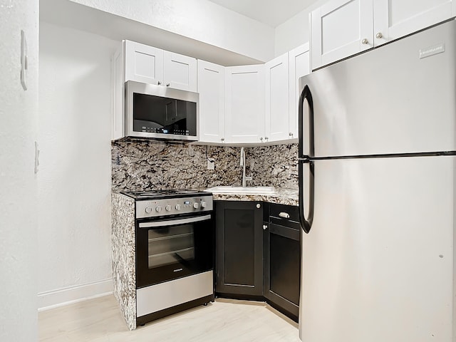 kitchen featuring sink, white cabinetry, tasteful backsplash, and appliances with stainless steel finishes