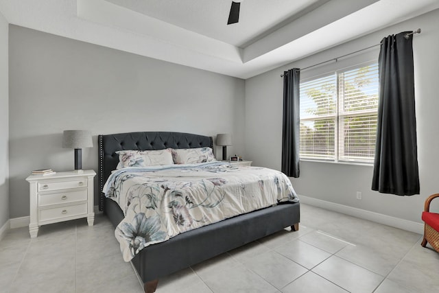 tiled bedroom featuring a raised ceiling and ceiling fan