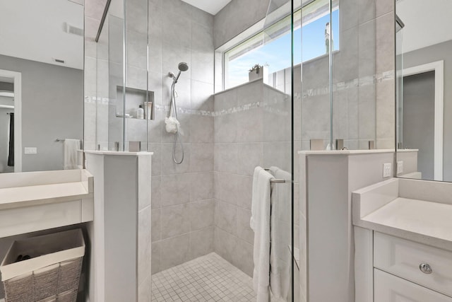 bathroom featuring tiled shower and vanity