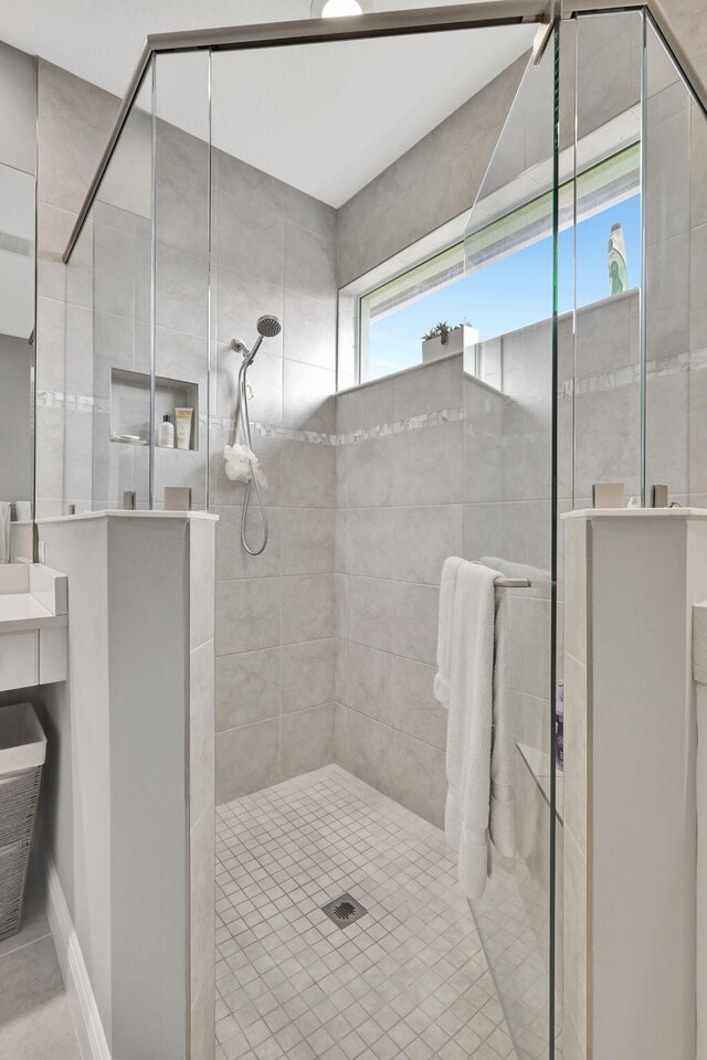 bathroom featuring a tile shower and tile patterned flooring