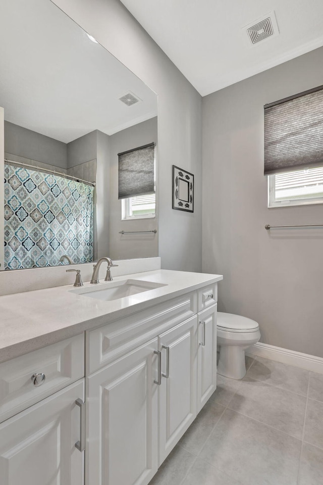 bathroom featuring toilet, a shower with shower curtain, tile patterned floors, and vanity