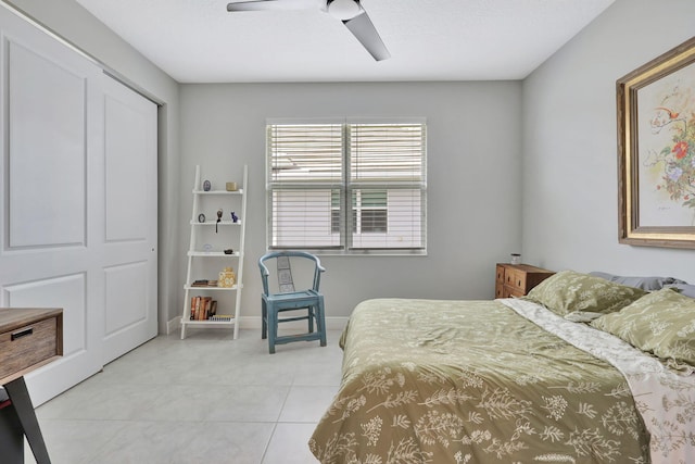 tiled bedroom featuring ceiling fan and a closet