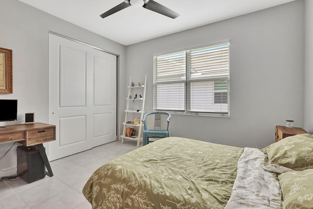 tiled bedroom featuring ceiling fan and a closet