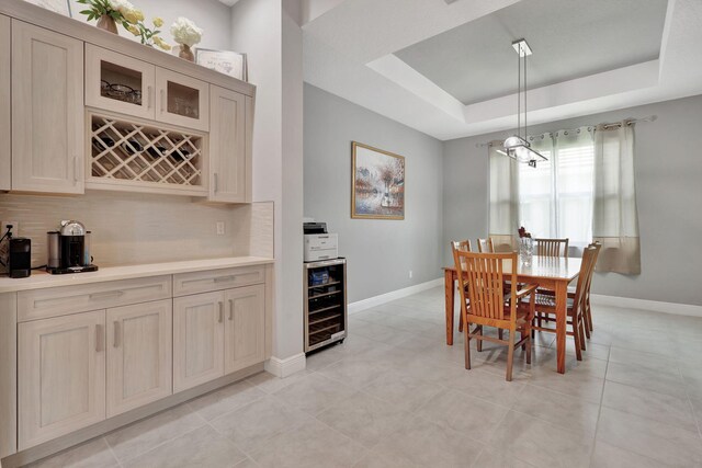 tiled dining space featuring a tray ceiling and wine cooler