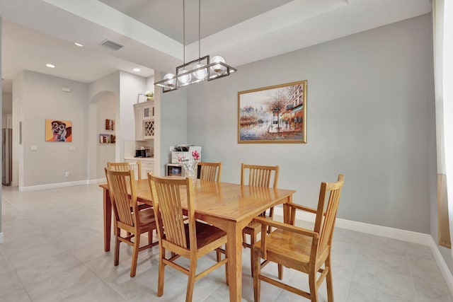 dining area with light tile patterned flooring and an inviting chandelier